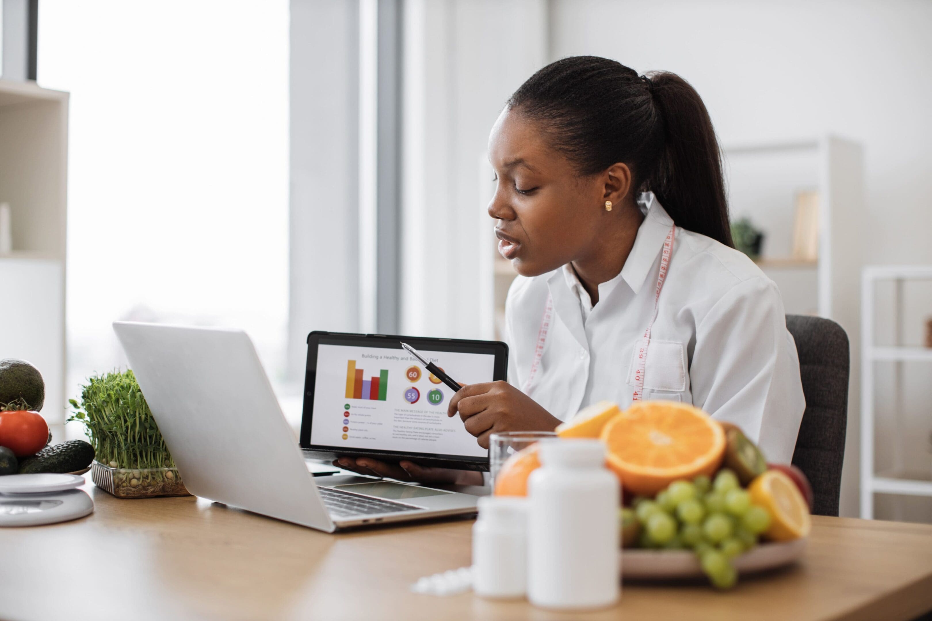 A woman sitting at a table looking at her laptop.